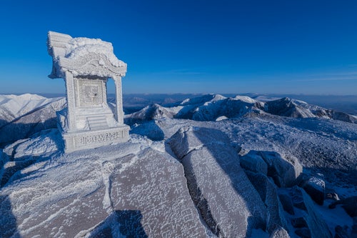 凍り付いた那須茶臼岳山頂の祠の写真