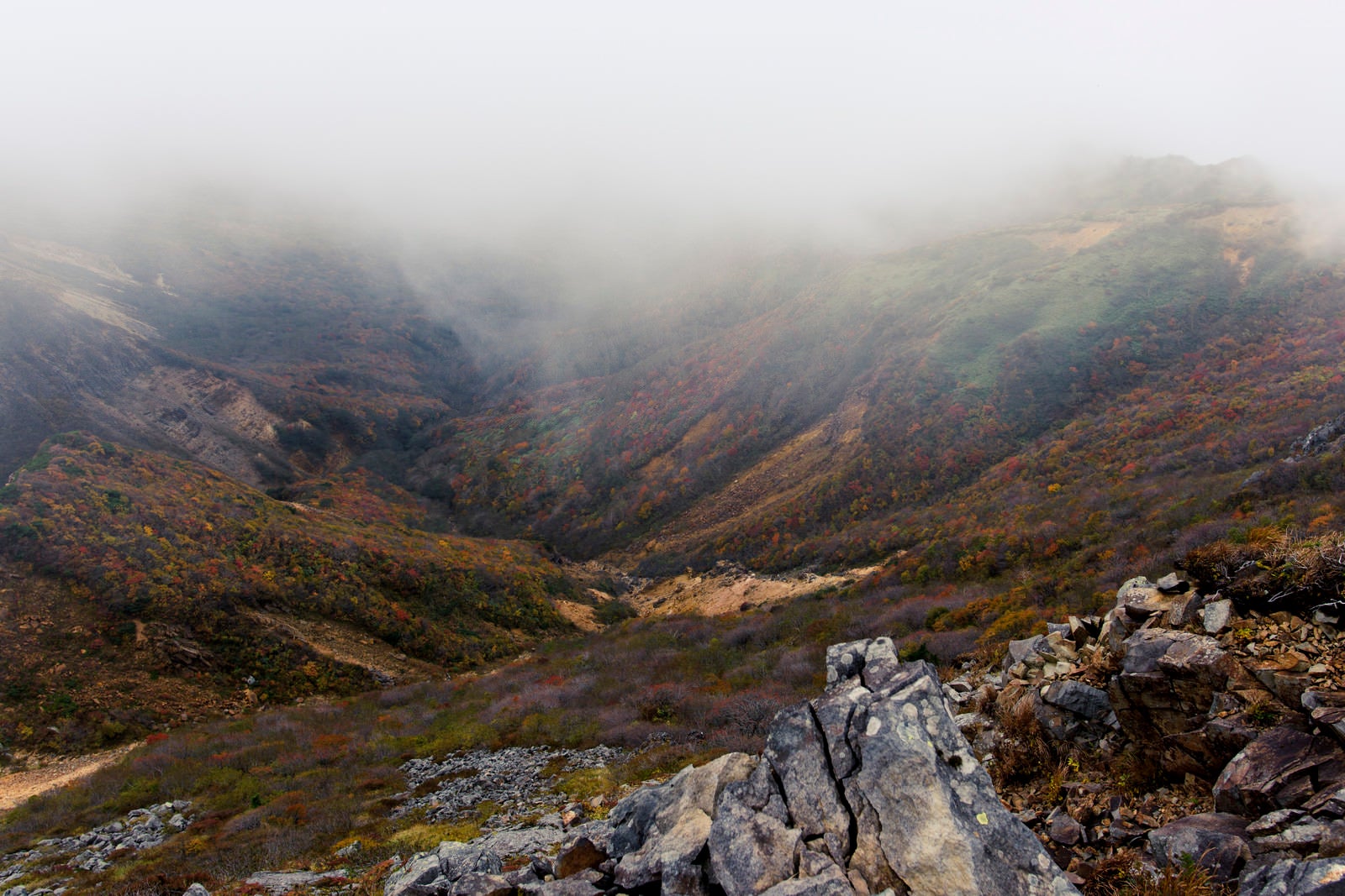 「分厚い雲の下の紅葉（那須岳）」の写真