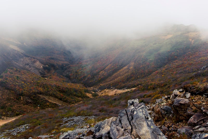 分厚い雲の下の紅葉（那須岳）の写真