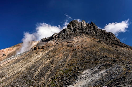 噴気と雲に彩られた那須茶臼岳（ちゃうすだけ）の写真