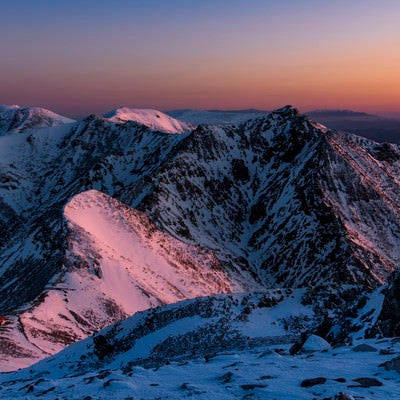 朝焼けに染まる雪化粧の那須岳の写真