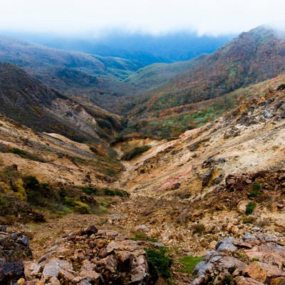 那須岳の裂けた谷間と中腹の紅葉の写真