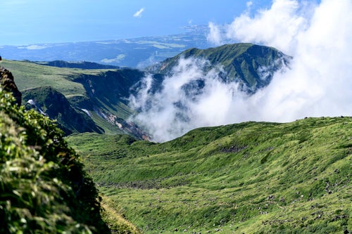 雲が湧き上がる鳥海山山頂の景観の写真