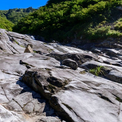 悠久の水の流れで削られた滑沢の岩（巻機山）の写真