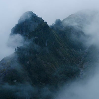 雲の中から浮かび上がる天狗岩（巻機山）の写真