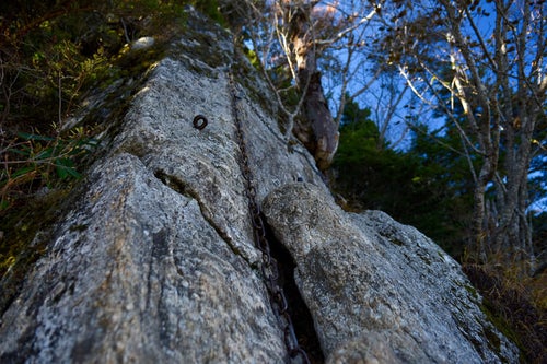 垂直に切り立つ岩にかけられた鎖（甲斐駒ヶ岳）の写真
