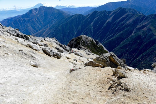 白砂の大地が目立つ甲斐駒ヶ岳山頂の景色の写真