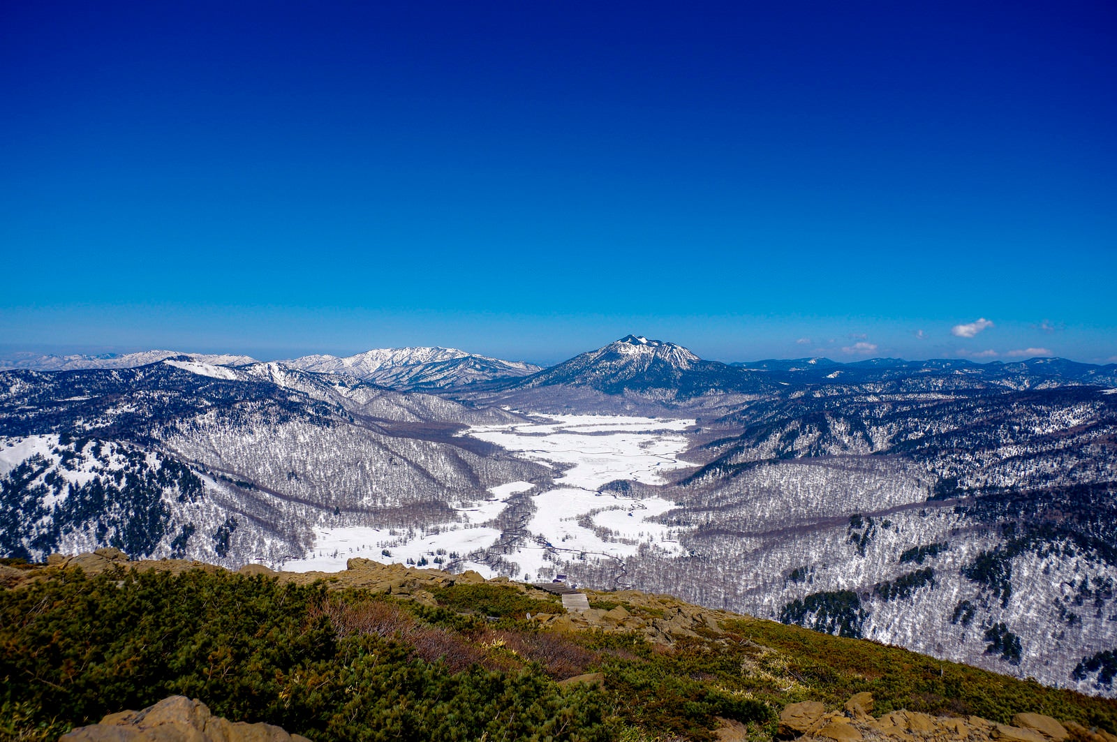 「雪が解け始めた至仏山の山肌と燧ヶ岳（ひうちがたけ）」の写真