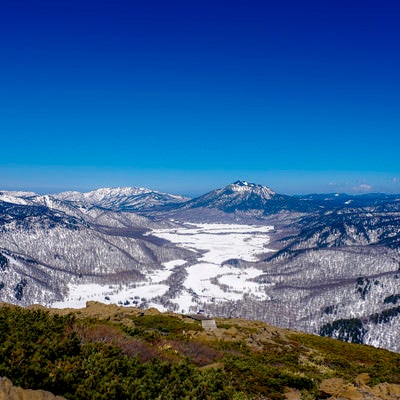 雪が解け始めた至仏山の山肌と燧ヶ岳（ひうちがたけ）の写真
