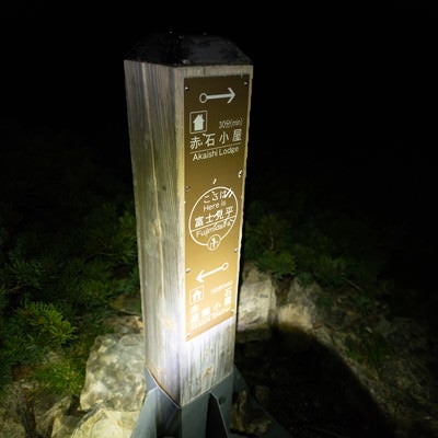 深夜にライトを当てた赤石岳にある指導標（南アルプス）の写真