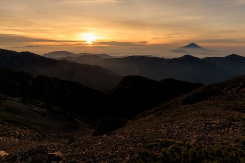 赤石岳山頂から拝むご来光と富士山（南アルプス）の写真