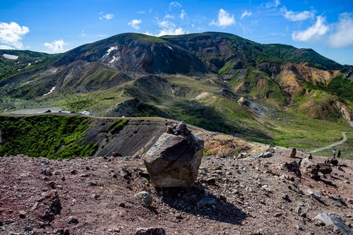 浄土平に転がる火山岩と一切経山の山並み（吾妻連峰）の写真