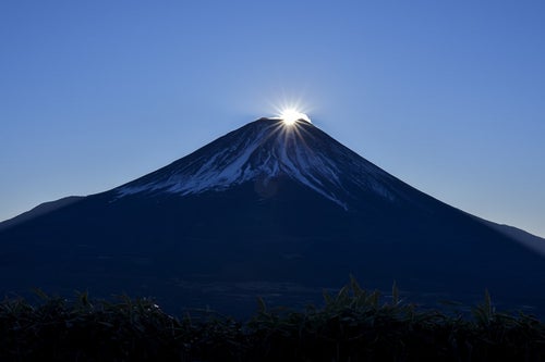 山頂に登り始めた太陽（富士山）の写真