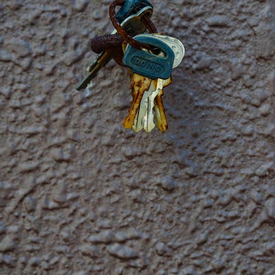 壁につるされた古びた鍵の束の写真