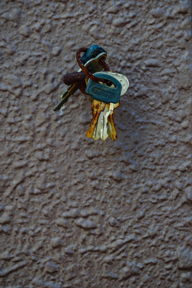 「壁につるされた古びた鍵の束」の写真