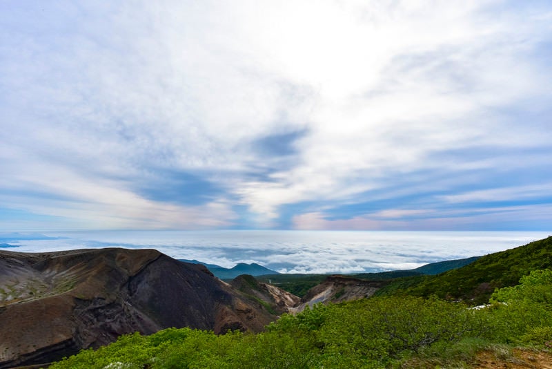 雲海と上層雲に挟まれた山々（蔵王山）の写真
