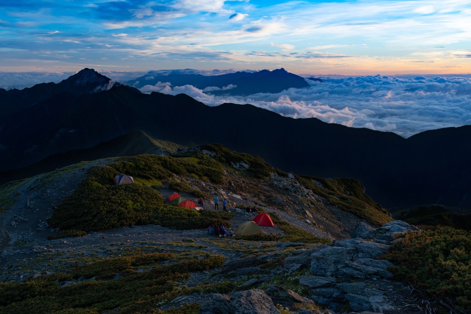 「南アルプスの壮大な夜明けを楽しむ登山者」の写真