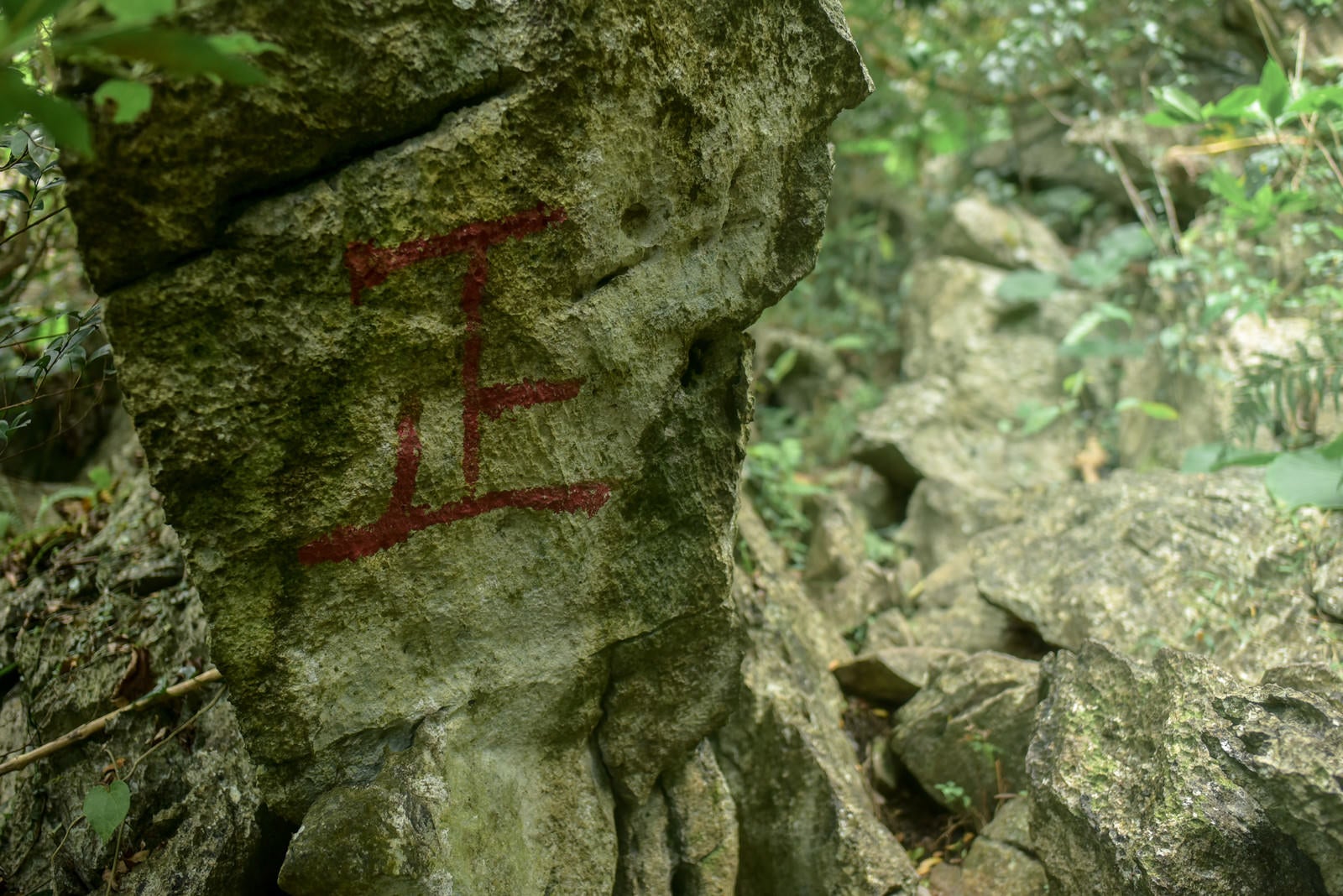 「登山道の岩壁に描かれた赤い正の字」の写真