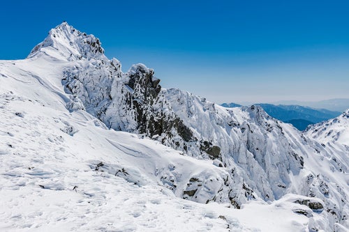 宝剣岳の頂に立つ登頂者（木曽山脈）の写真