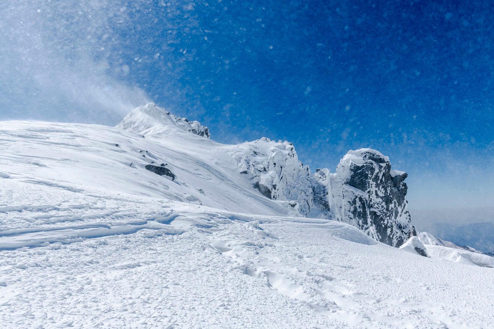 「強風で舞い上がる斜面の雪（木曽駒ヶ岳）」の写真