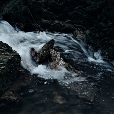渓流に磨かれる岩の写真