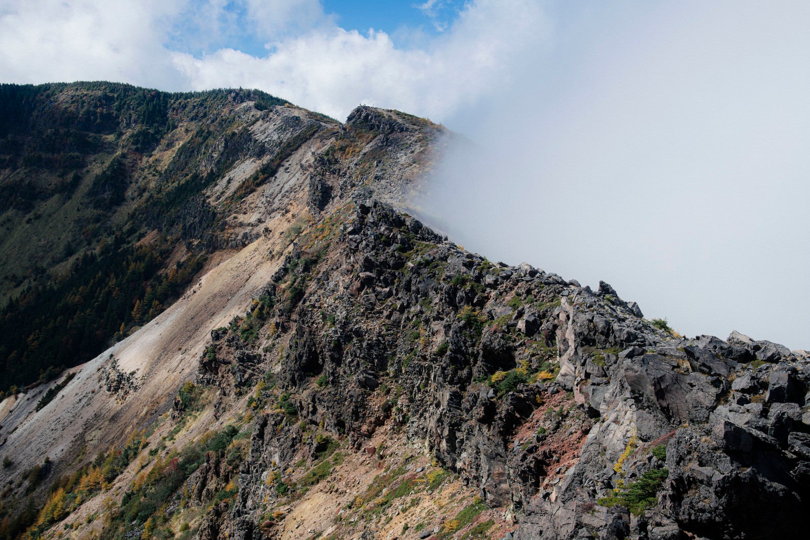 「雲が押し寄せる外輪山と稜線」の写真