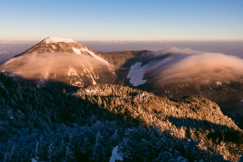 朝焼けと滝雲流れる冬の蓼科山の写真