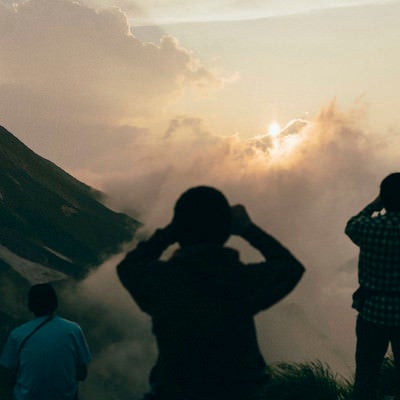 夕日を撮影する登山者たちの写真