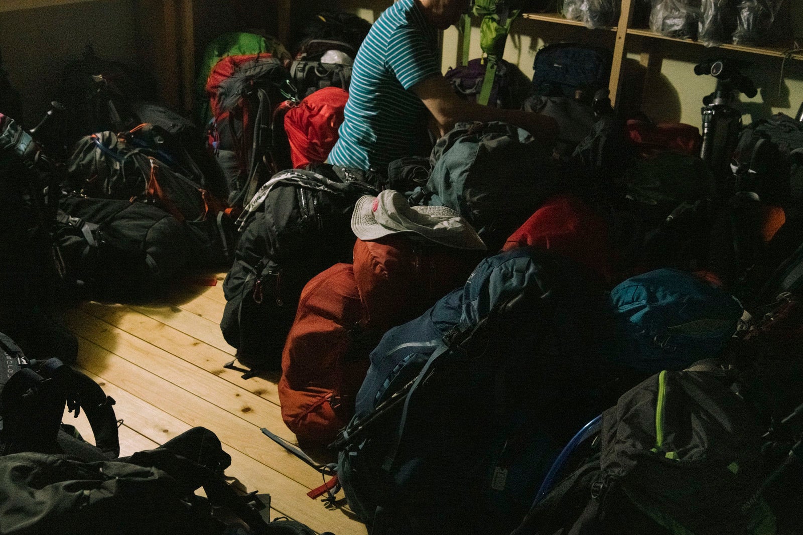 「登山者のザックを並べる小屋番」の写真