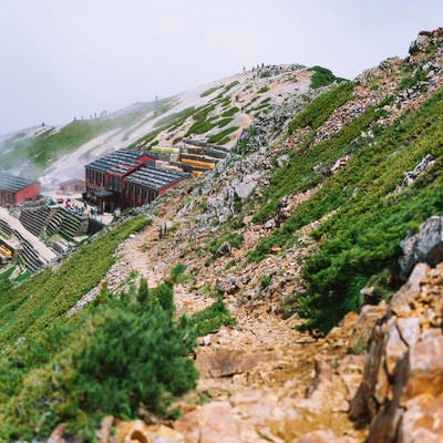 登山道の先の唐松岳頂上山荘の写真