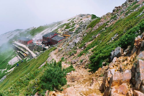 登山道の先の唐松岳頂上山荘の写真