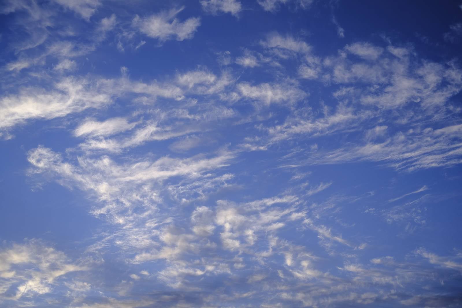 「散り散りの雲が舞う空」の写真