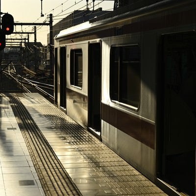 朝日に照らされる電車の写真