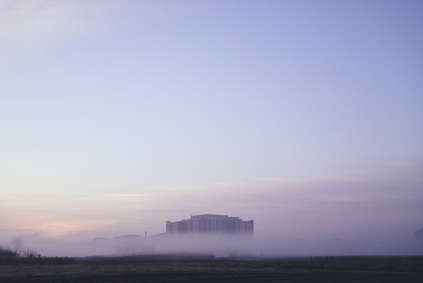 「朝霧から顔を出す建物」の写真