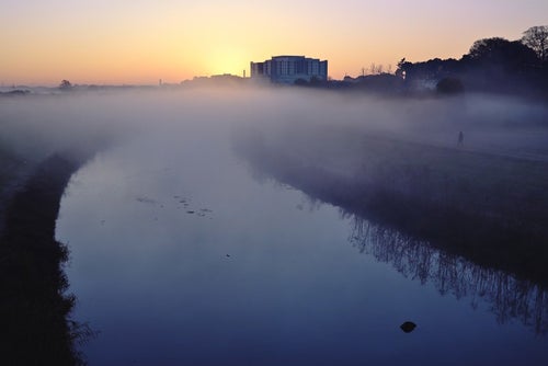 朝霧立ち込める河川の写真