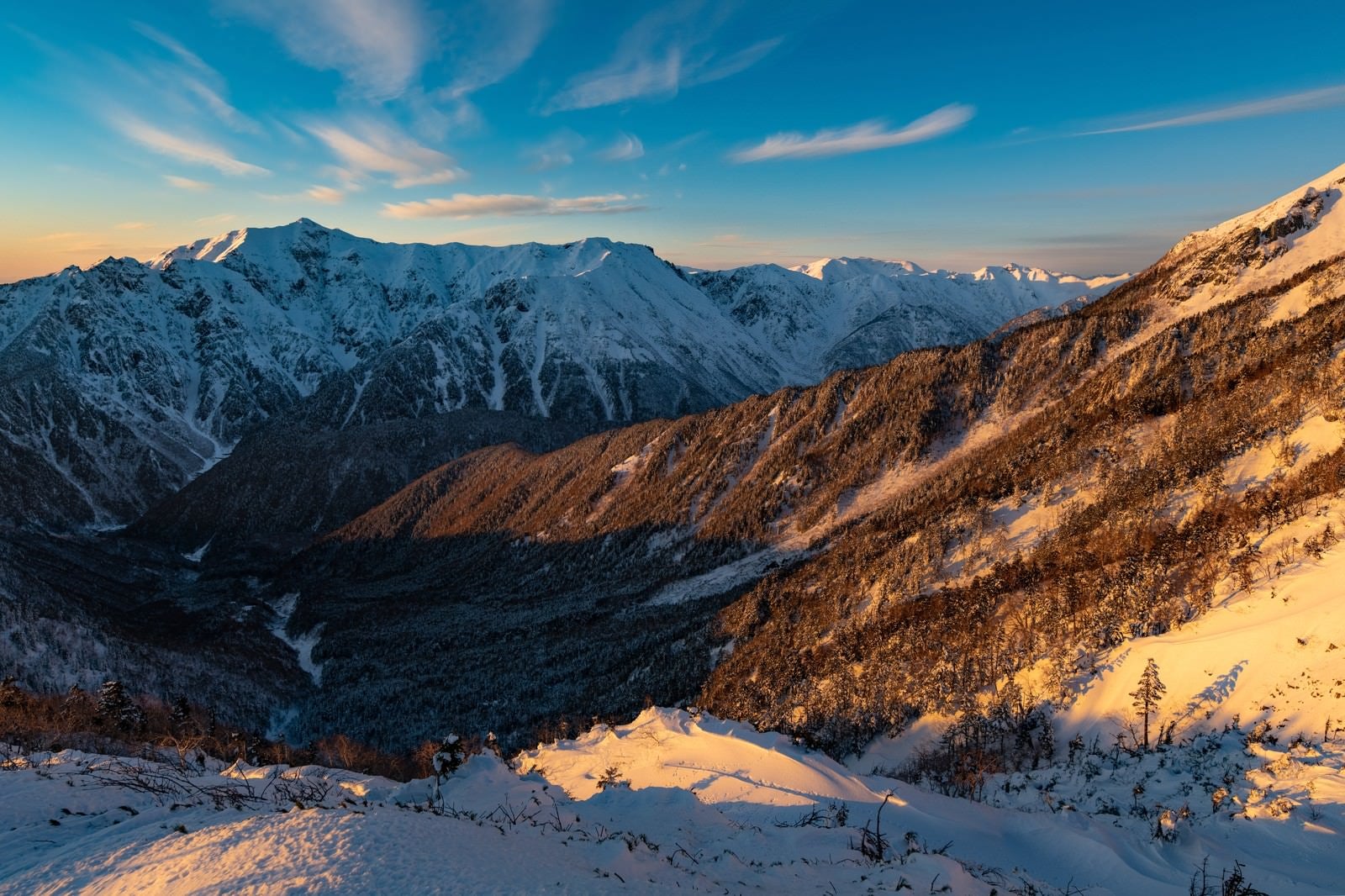 「西穂高岳から見る冬の笠ヶ岳」の写真