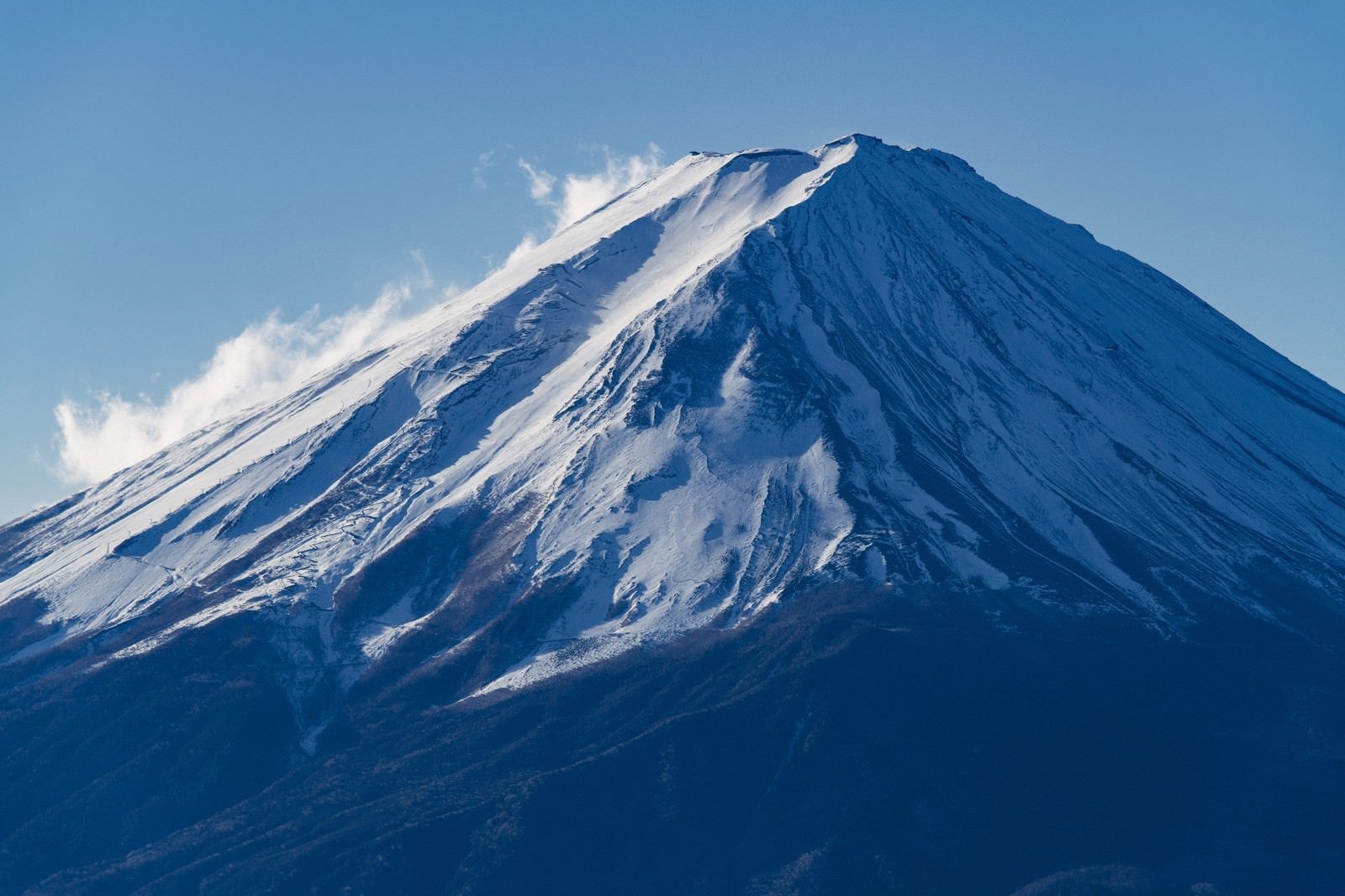 「雪煙を上げる富士山」の写真