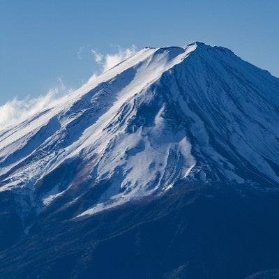 雪煙を上げる富士山の写真