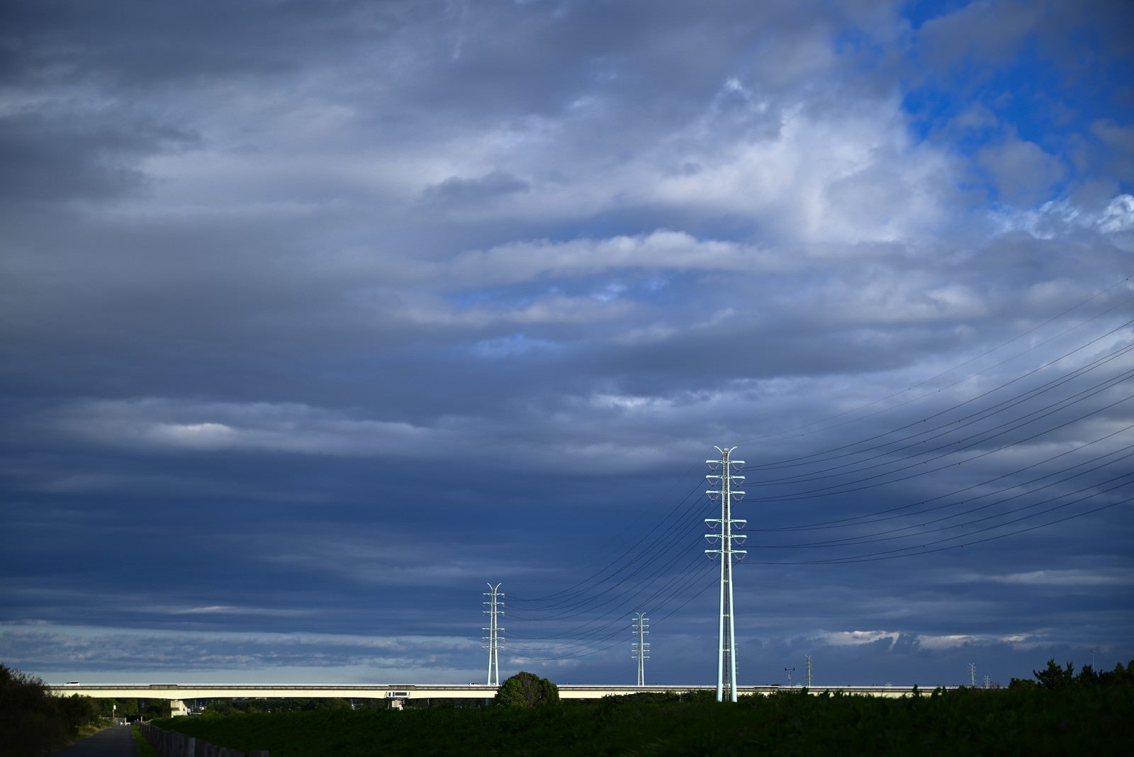 「靡く雲と送電線」の写真