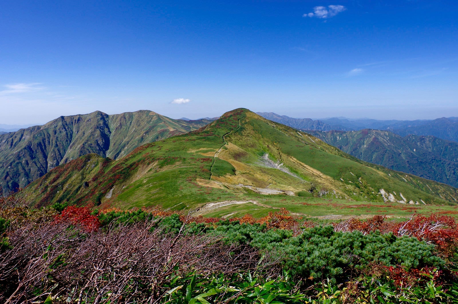「大朝日岳避難小屋とその奥の山々の景色」の写真