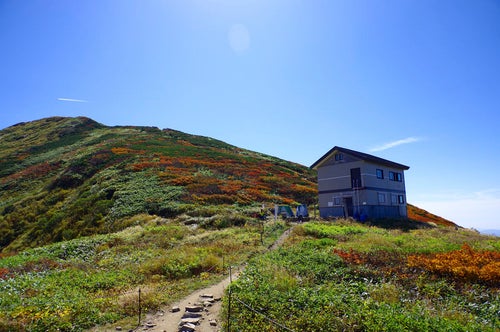 大朝日岳避難小屋と山頂方面の景色の写真