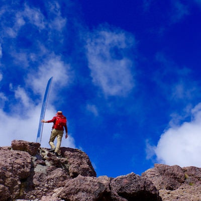 男体山の刀と赤い登山者の写真