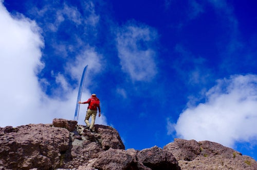 男体山の刀と赤い登山者の写真