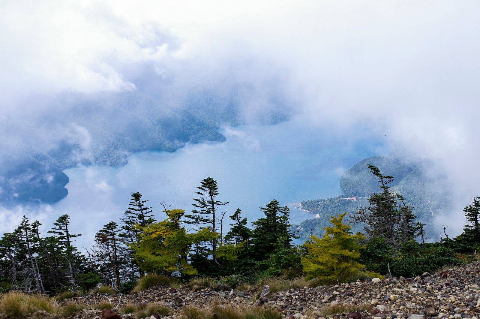 「男体山山頂から見る雲に包まれた中禅寺湖（ちゅうぜんじこ）」の写真