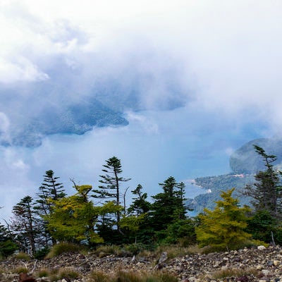 男体山山頂から見る雲に包まれた中禅寺湖（ちゅうぜんじこ）の写真