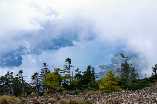 男体山山頂から見る雲に包まれた中禅寺湖（ちゅうぜんじこ）の写真