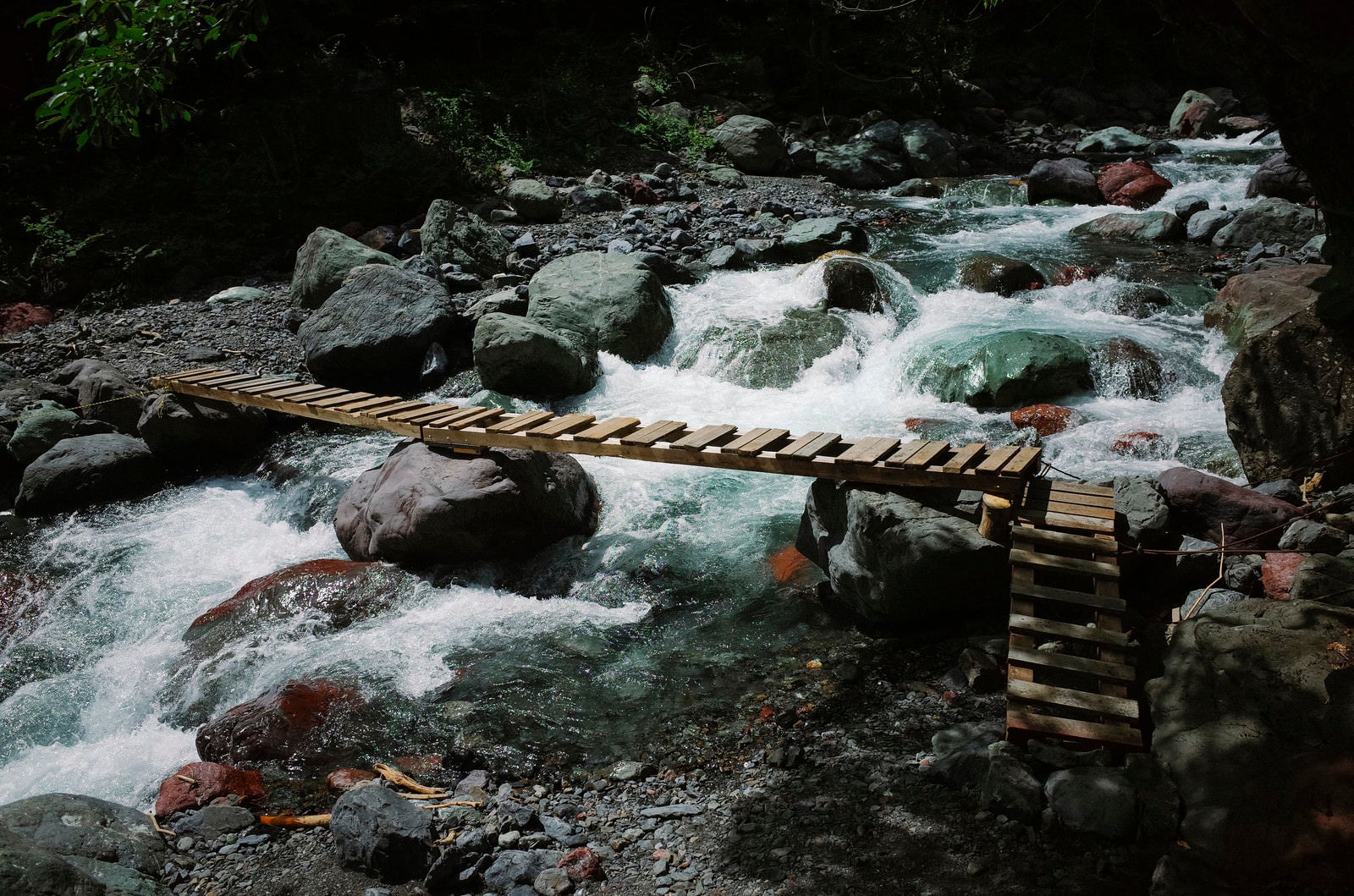 「聖岳山中を流れる渓流とかけられた橋」の写真
