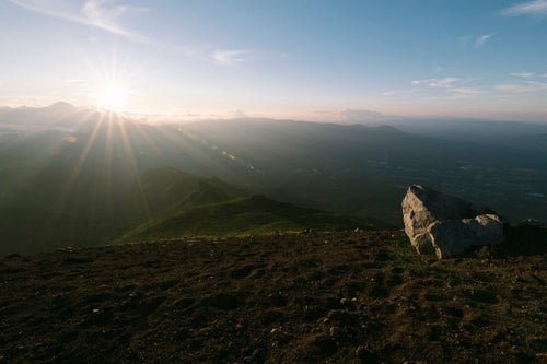 夕日を受ける岩手山山頂の岩々と鬼ヶ城コース方面の写真