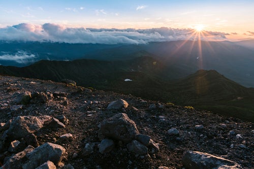 岩手山に照り付ける夕日と輝く地面の写真