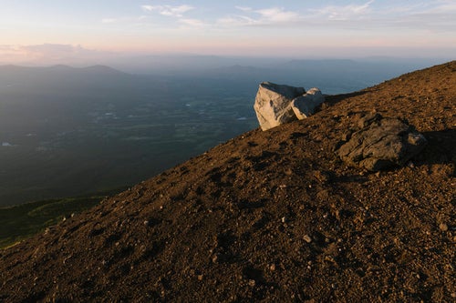 火山岩と喉かな麓の景色（岩手山）の写真